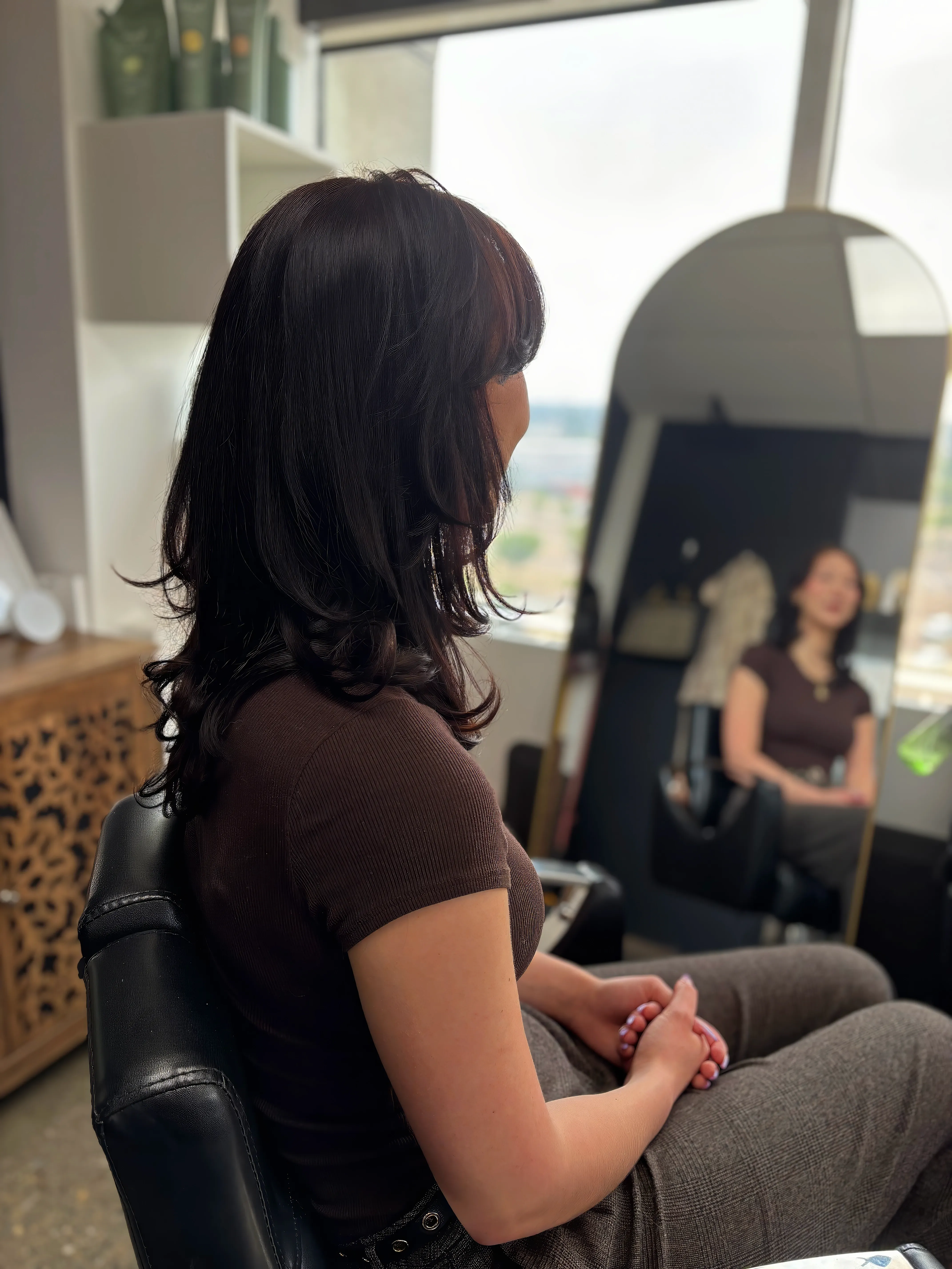 Brunette looking admirably at studio mirror, proud